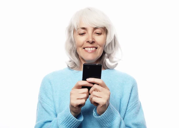 Ifestyle, familj och människor koncept: gamla farmor pratar med sina barnbarn via telefon, leende och hälsning dem — Stockfoto