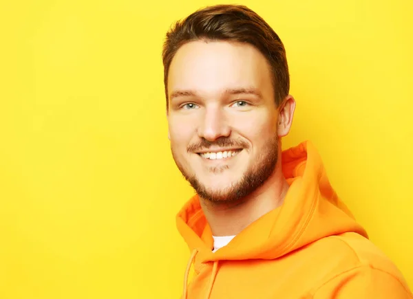 Portrait of a smart young man wearing casual standing against yellow background — Stock Photo, Image
