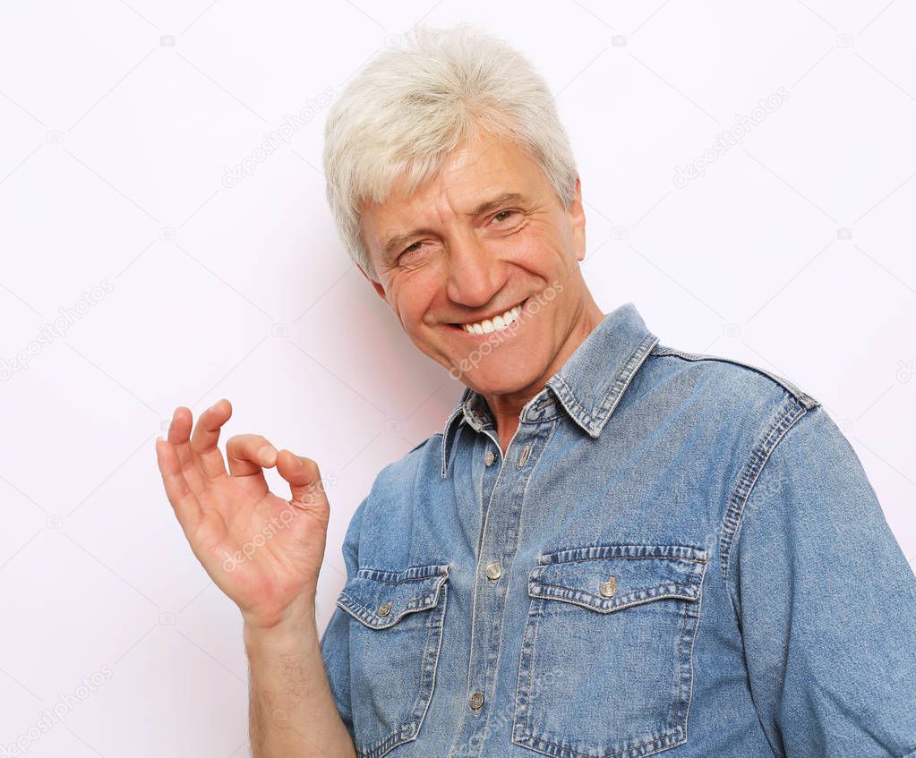 lifestyle, emotion  and people concept: Handsome mature man in casual wear is showing Ok sign