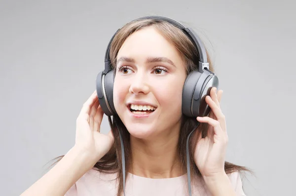 Jeune femme dans les écouteurs écouter de la musique — Photo