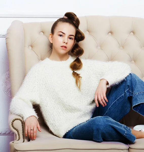 Elegant tonåring flicka i casual kläder sitter på soffan och poserar — Stockfoto