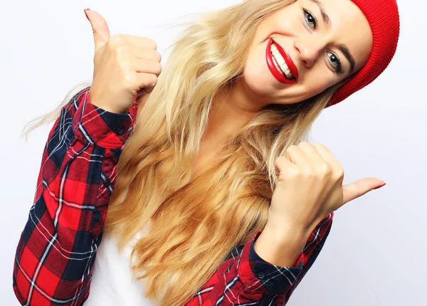 Bonita jovem hipster mulher loira com brilhante sexy compõem vestindo elegante camisa xadrez urbana e chapéu vermelho, fundo branco . — Fotografia de Stock