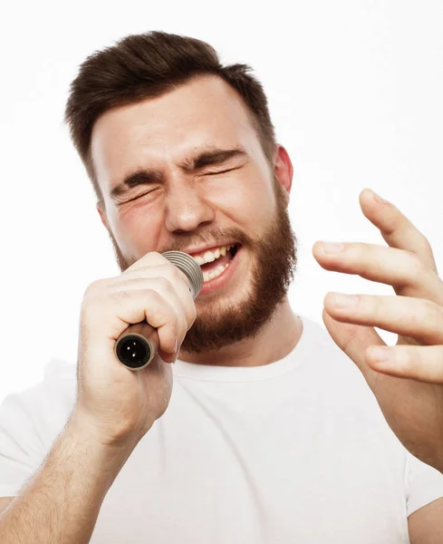 Giovane uomo barbuto in camicia bianca che canta in microfono — Foto Stock