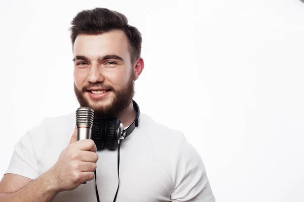Jeune homme barbu en chemise blanche chantant au microphone — Photo