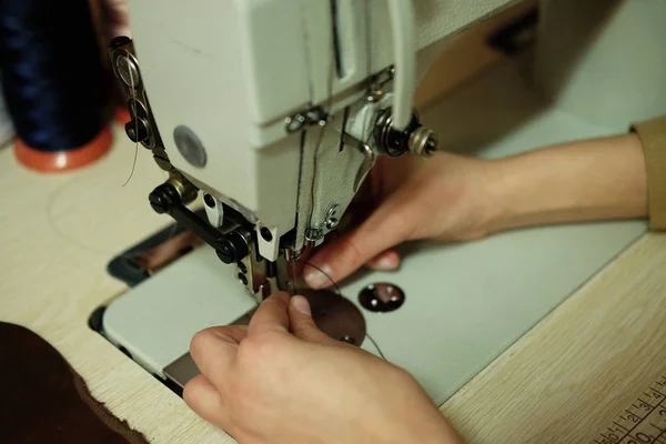 Closeup on young woman sewing leather handbag — Stock Photo, Image