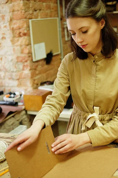 Donna piega scatola di imballaggio nel laboratorio di cucito — Foto Stock