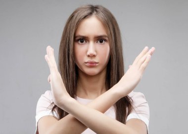  Güzel genç bayan gri arka plana hayır diyor.