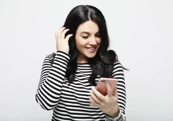 Ung kvinna med långt hår, håller modern mobiltelefon — Stockfoto