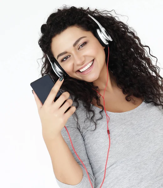 Estilo de vida y el concepto de la gente: Hermosa mujer joven escuchando música en auriculares con teléfono inteligente —  Fotos de Stock