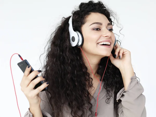 Estilo de vida y el concepto de la gente: Hermosa mujer joven escuchando música en auriculares con teléfono inteligente —  Fotos de Stock