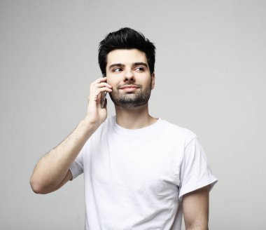 tehnology, duygu ve insanlar kavramı: smartphone tarafından konuşan gülümseyen genç adam