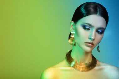 Renkli parlak ışıklarıyla stüdyoda poz veren yüksek model kadın..