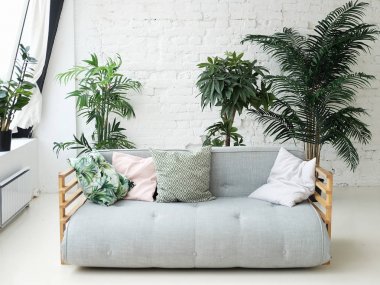 çiçeklerin yanındaki odada gri kanepe