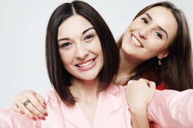 Pijama giymiş iki güzel kız kucaklaşıp selfie çekiyorlar.