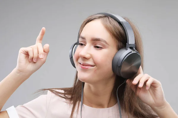 Jovem mulher em fones de ouvido ouvindo música — Fotografia de Stock