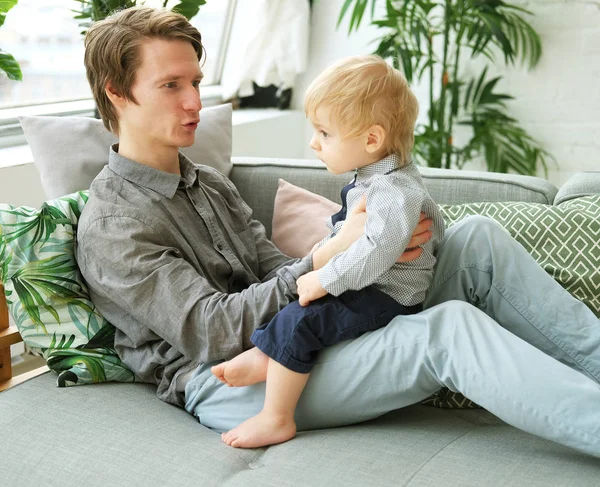 Estilo de vida, família e conceito de pessoas - Pai jovem feliz com seu filho de um ano de idade brincando em casa — Fotografia de Stock