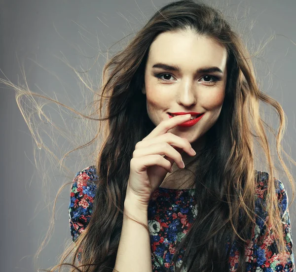 Modelo femenino positivo con expresión alegre, vestido con ropa casual, sobre fondo gris — Foto de Stock