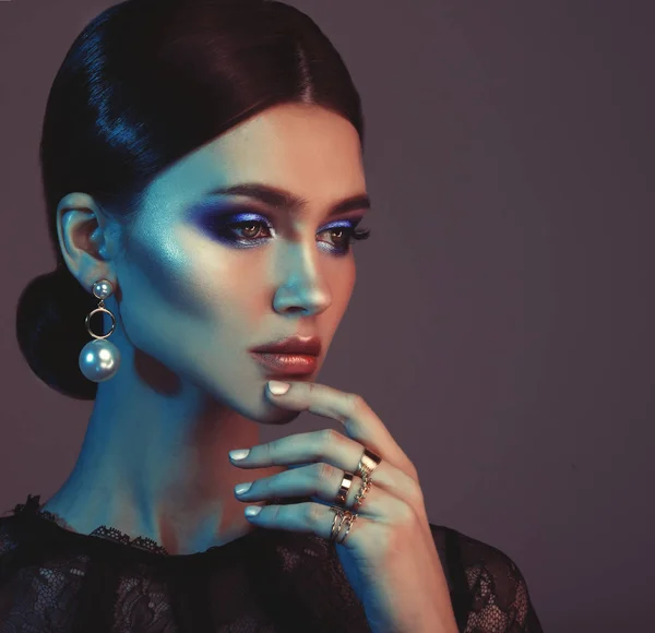 Krásné módní model nosí elegantní šperky v barevné světlo — Stock fotografie