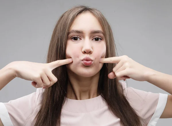 Jovem fêmea positiva com expressão alegre, vestida com roupas casuais, sobre fundo branco. Mulher bonita interior. Conceito de estilo de vida — Fotografia de Stock