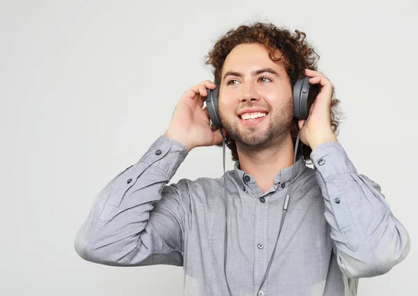 Απολαμβάνοντας τον ήχο της μουσικής. Το πορτρέτο όμορφος νεαρός άνδρας με τα ακουστικά στούντιο. — Φωτογραφία Αρχείου