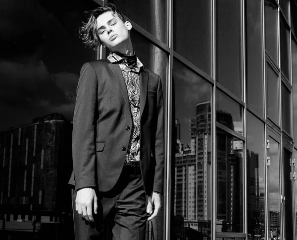 Portrait of sexy handsome fashion nale model dressed in elegant suit posing outdoor. Long haired Metrosexual. — Stock Photo, Image