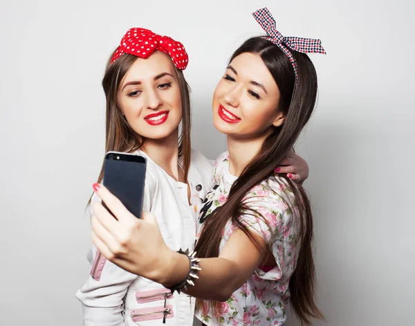 Технология, дружба и концепция людей - два улыбающихся подростка фотографируются с камерой на смартфоне — стоковое фото