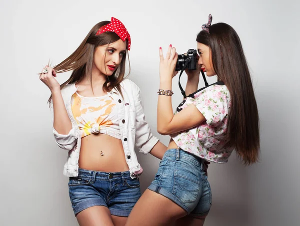 Estilo de vida y el concepto de la gente: Dos amigas jóvenes de pie juntos y divirtiéndose. Mirando la cámara. —  Fotos de Stock