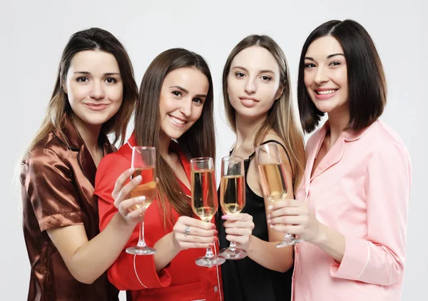 Schöne Mädchen im Pyjama trinken Champagner und haben Spaß — Stockfoto