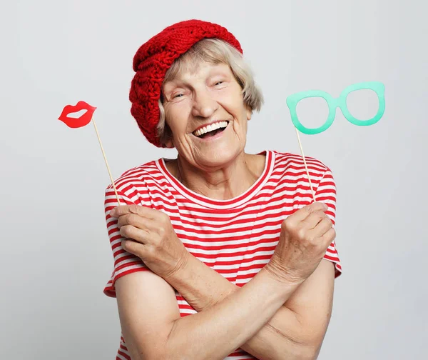 Estilo de vida, la gente y el concepto de fiesta: abuela divertida con ropa roja lista para la fiesta — Foto de Stock