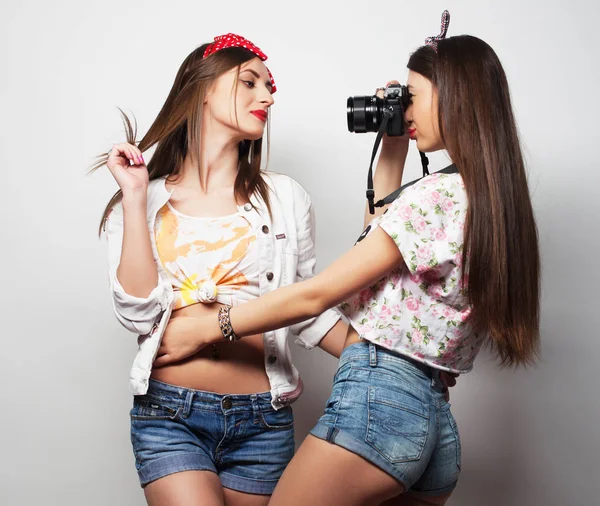 Estilo de vida, la moda y el concepto de la gente: Dos amigas jóvenes de pie juntos y divirtiéndose . —  Fotos de Stock