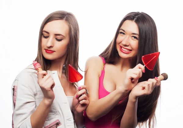 Hipster meisjes Holding Candys. Studio portret van twee vrolijke beste vrienden met plezier en het maken van grappige gezichten — Stockfoto