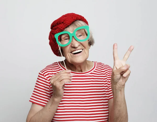 Lifestyle, emotion  and people concept: funny grandmother with fake glasses, laughs and ready for party — Stock Photo, Image