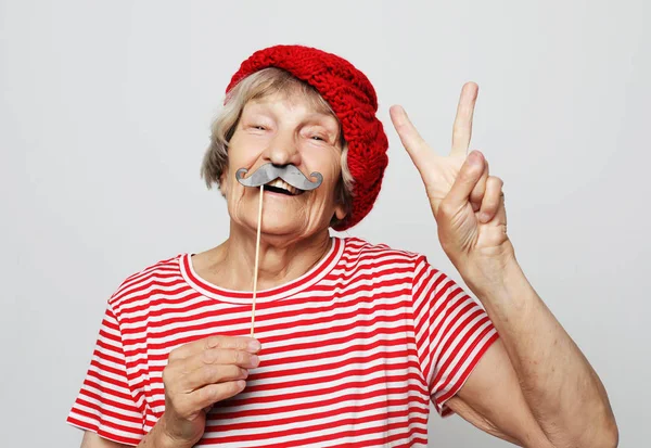 Estilo de vida, la gente y el concepto de fiesta: abuela divertida con ropa roja lista para la fiesta — Foto de Stock