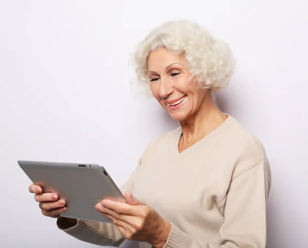 Стиль жизни, технологии и концепция людей: счастливая зрелая женщина с помощью планшета, общается с детьми — стоковое фото