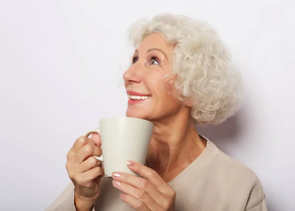 Idade animado senhora sorrindo rindo, segurando xícara beber café, chá, sobre fundo branco — Fotografia de Stock