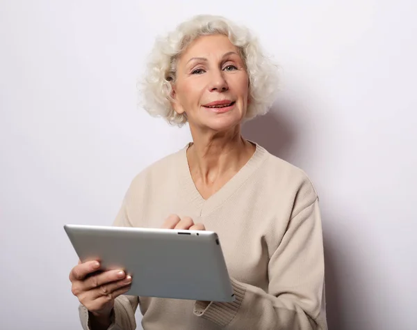 Estilo de vida, tecnologia e conceito de pessoas: Mulher madura feliz usando um tablet, se comunica com as crianças — Fotografia de Stock