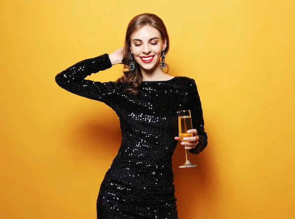 Styl życia, zabawa i koncepcja ludzi: piękna dziewczyna w sukience koktajlowej z kieliszkiem szampana — Zdjęcie stockowe