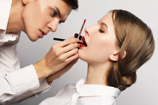 Jovem bela mulher aplicando maquiagem por artista de maquiagem — Fotografia de Stock
