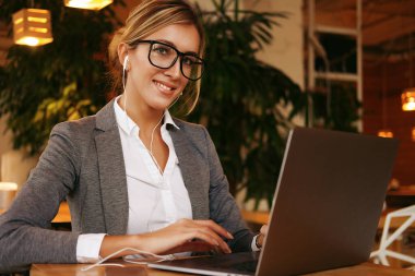 Kafede dizüstü kullanarak iş wooman. Bir kafede otururken ve bilgisayarda çalışan genç güzel kız