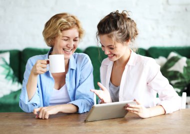 yaşam tarzı, teknoloji ve insan kavramı: evde tablet bilgisayar kullanarak anne ve yetişkin kızı