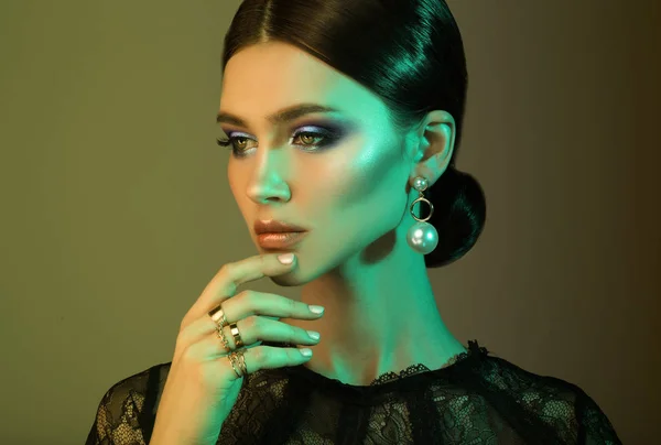 Krásné módní model nosí elegantní šperky v barevné světlo — Stock fotografie