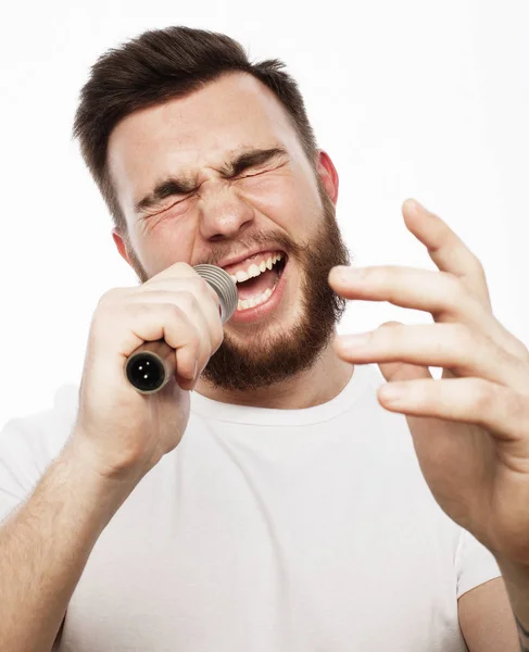 Νέοι γενειοφόρος άντρας στο τραγούδι λευκό πουκάμισο στο μικρόφωνο — Φωτογραφία Αρχείου