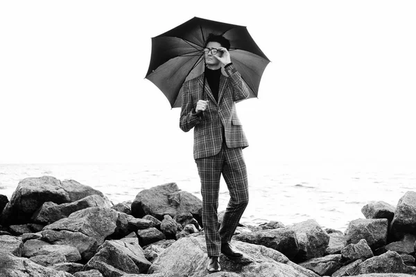 Jovem elegante com guarda-chuva em pé perto do mar — Fotografia de Stock