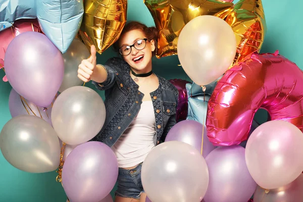 Retrato de menina ruiva feliz à espera de festa. Linda alegre jovem mulher se divertindo com balões cintilantes, sobre fundo azul . — Fotografia de Stock