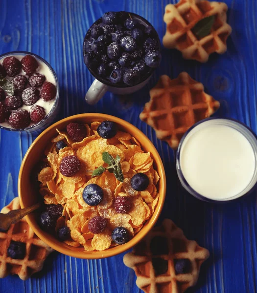 Здоровый завтрак. Кукурузные хлопья с малиной и черникой, мюсли с йогуртом и ягодами, вафли и молоко . — стоковое фото