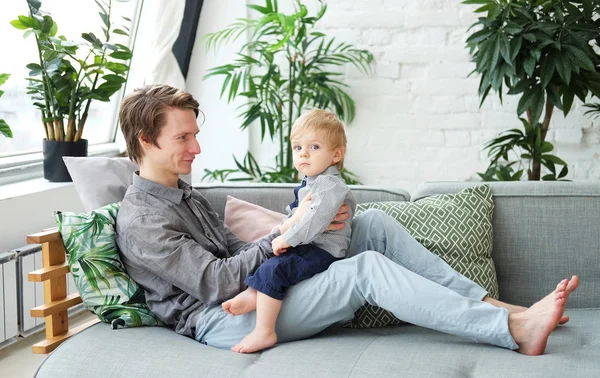 Életmód, család és emberek fogalma-boldog fiatal apa az ő egy éves fia játszik otthon — Stock Fotó