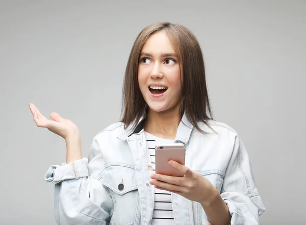 Счастливая взволнованная женщина рада получать текстовые сообщения, смотрит на мобильный телефон — стоковое фото