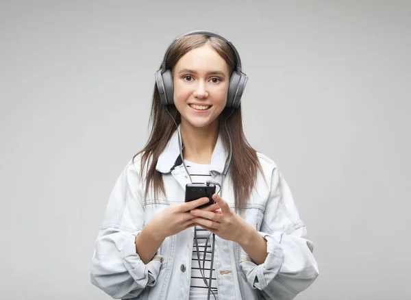 Piękna młoda kobieta, słuchanie muzyki w słuchawkach z smartphone — Zdjęcie stockowe