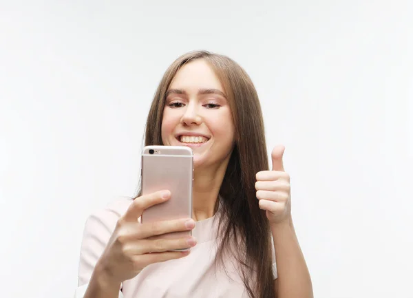 Счастливая улыбающаяся молодая женщина, делающая селфи со смартфоном — стоковое фото