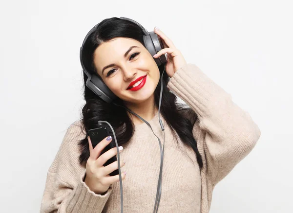 Joven mujer morena con curvas en auriculares escuchando música —  Fotos de Stock